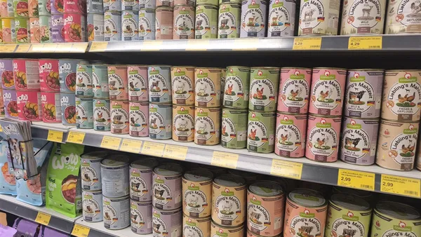 Hundefutter-Regal mit verschiedenen Dosenkonserven im Zoofachhandel